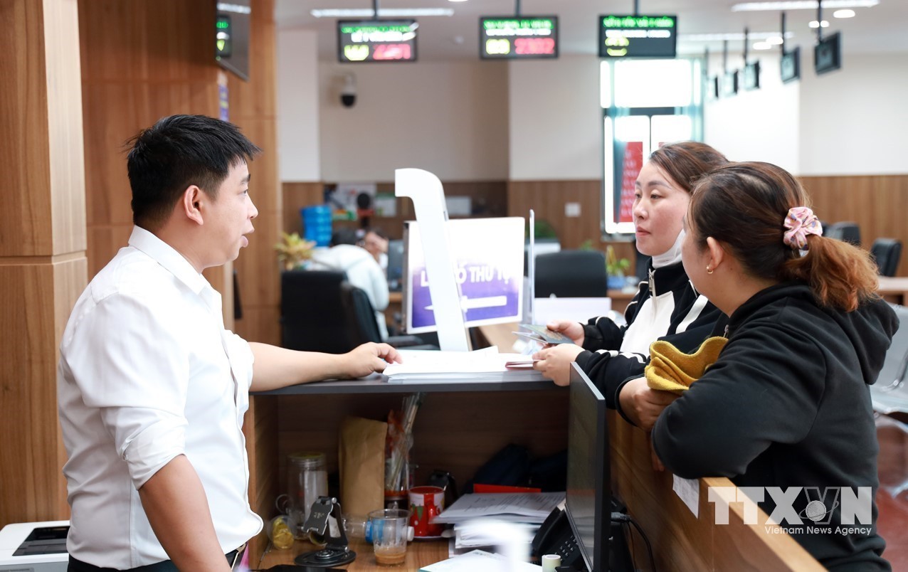 Cán bộ hướng dẫn người dân đến Trung tâm Phục vụ hành chính công tỉnh Khánh Hòa để giải quyết các thủ tục cần thiết. (Ảnh: Xuân Triệu/TTXVN)